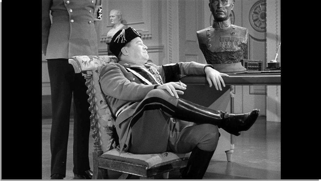 於《The Great Dictator》中，以兩張可調節高度的舊式理髮椅，表達諷刺與詼諧的戲劇效果。