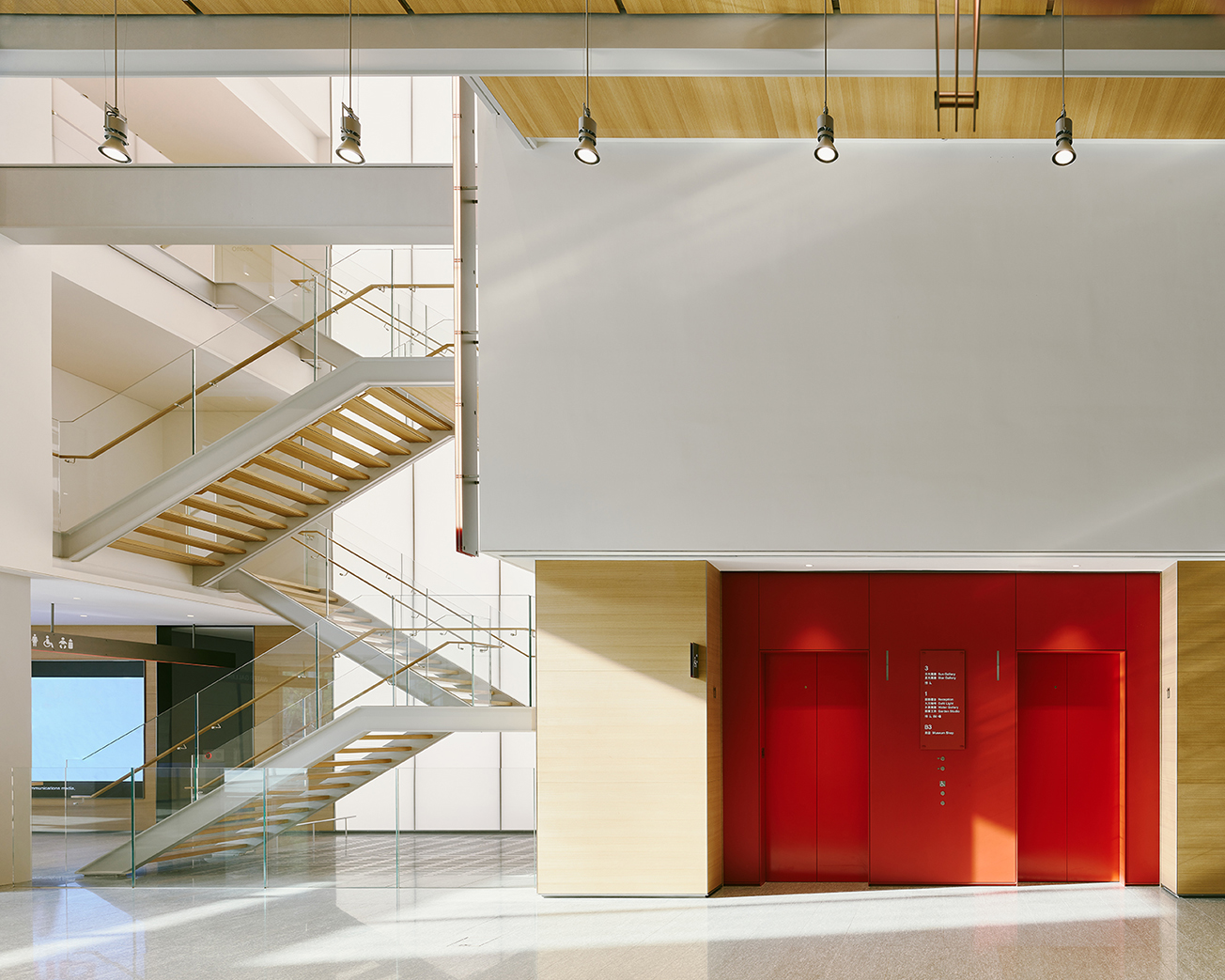 美術館大廳電梯選擇獨具特色的鮮明紅色，與美術館建築上方的紅色吊臂相互呼應。（攝影：Lucas K. Doolan）