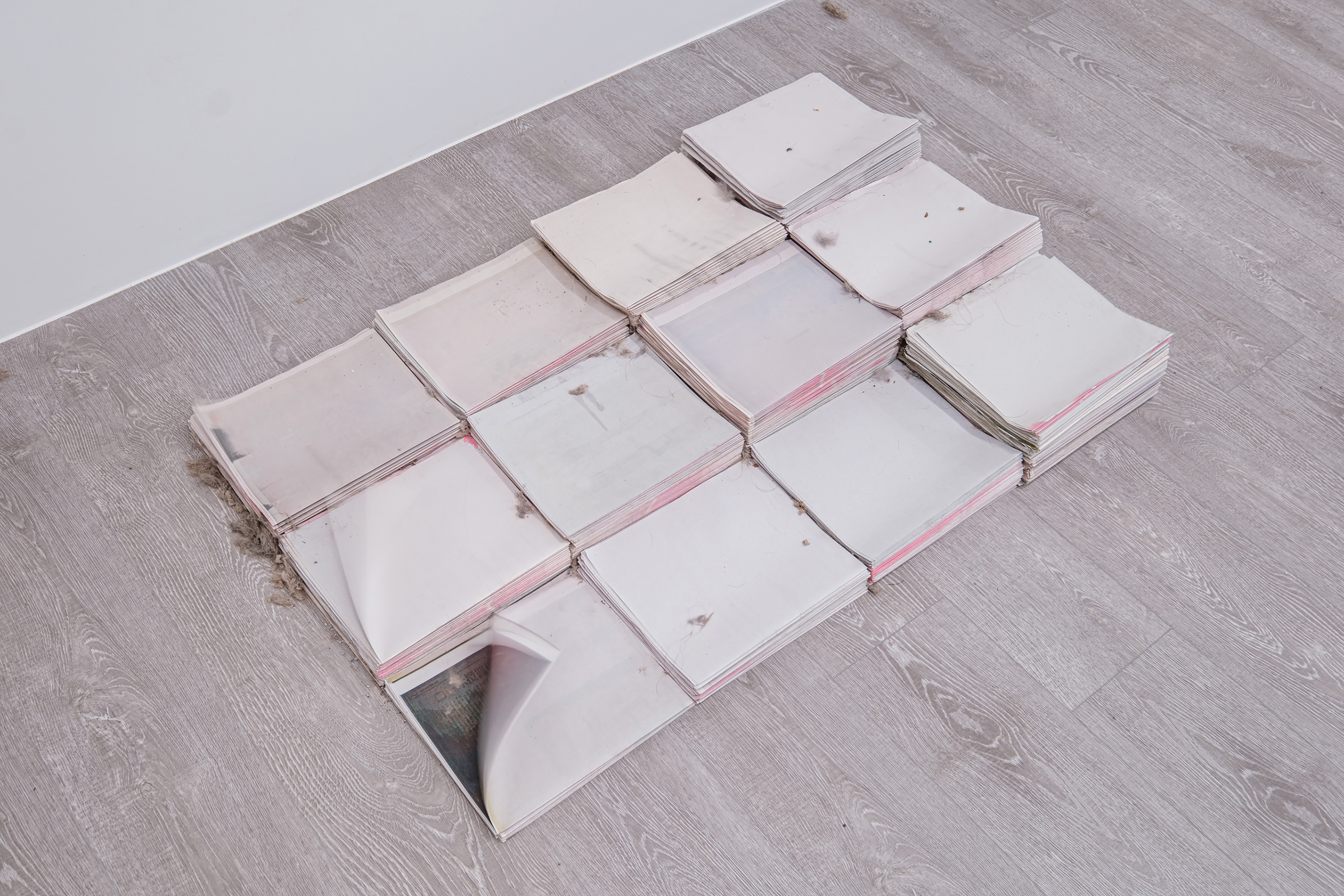 湯雅雯,《揚起》,2023,送風裝置、格柵出風口、蛇型簾、沙礫、灰塵、白報紙、抹布,尺寸依空間而定。圖像由藝術家提供。